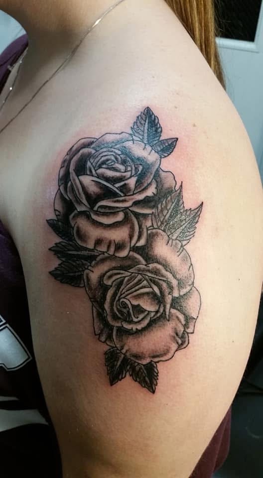 Two black and grey roses with feather arrow shoulder tattoo