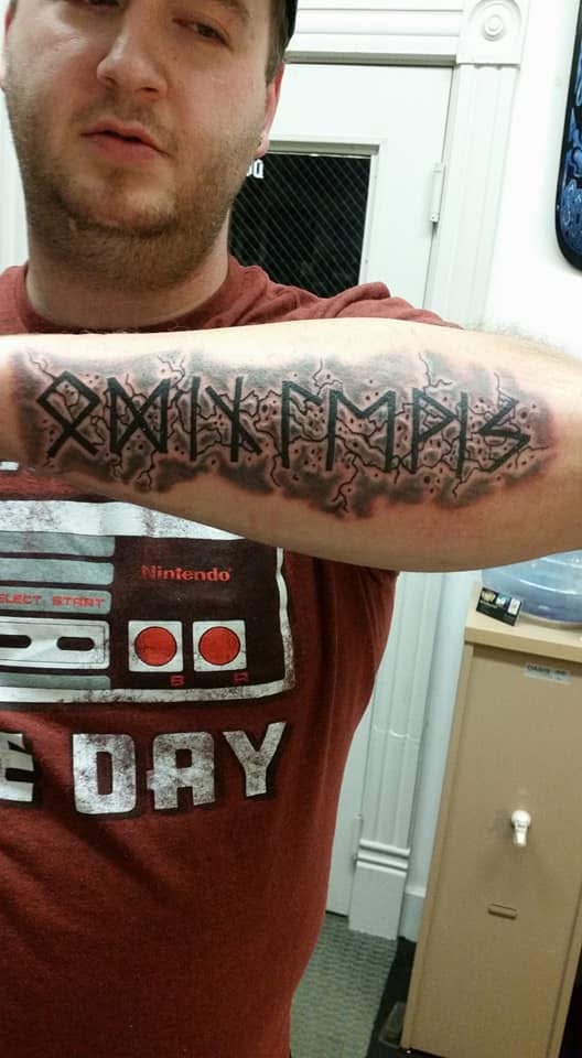 Elder Futhark runic text with lightning and smoke forearm tattoo