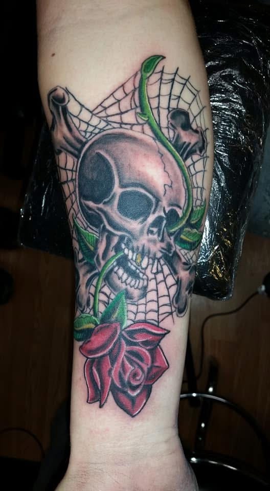 Skull with spider web and red rose forearm tattoo