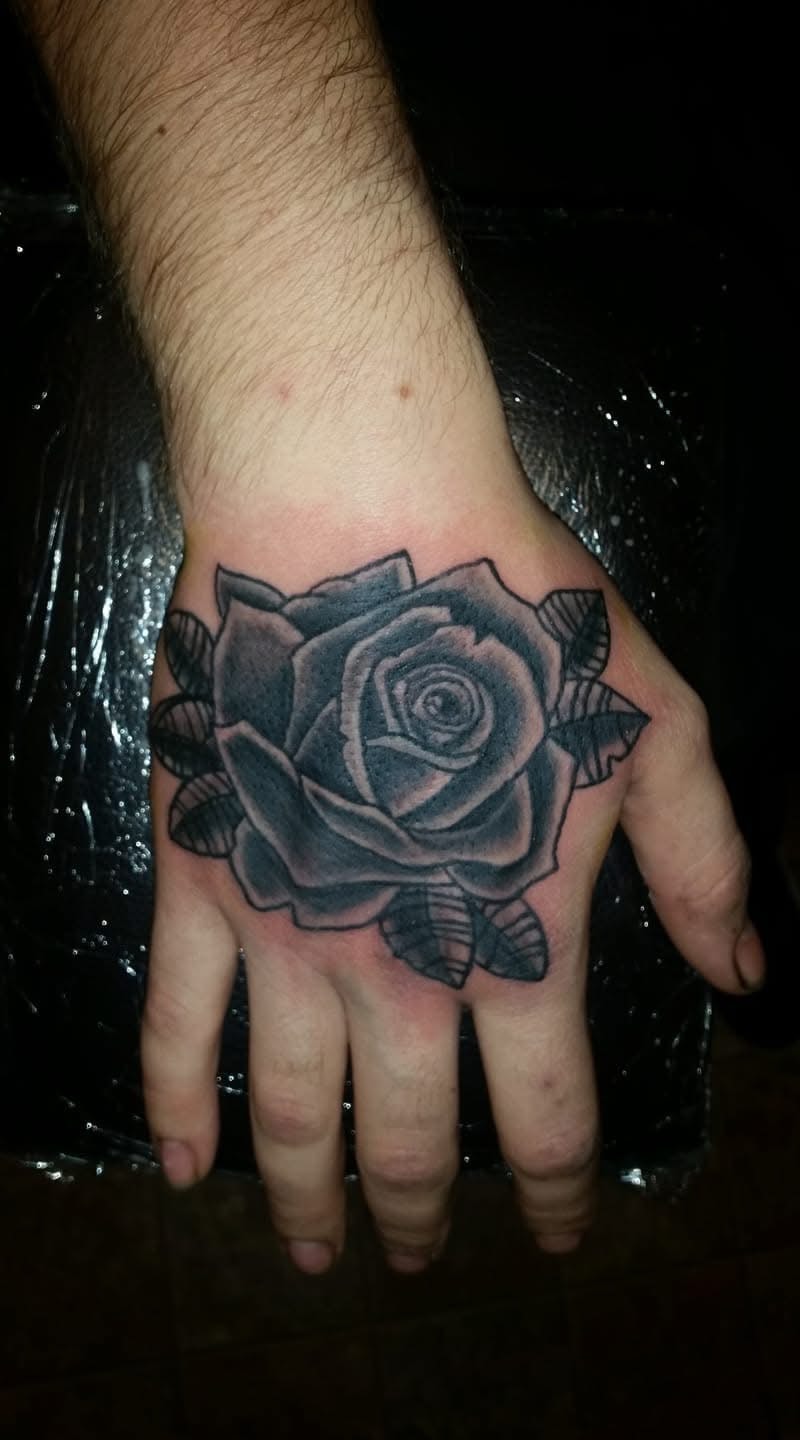 Bold black and grey rose with leaves hand tattoo