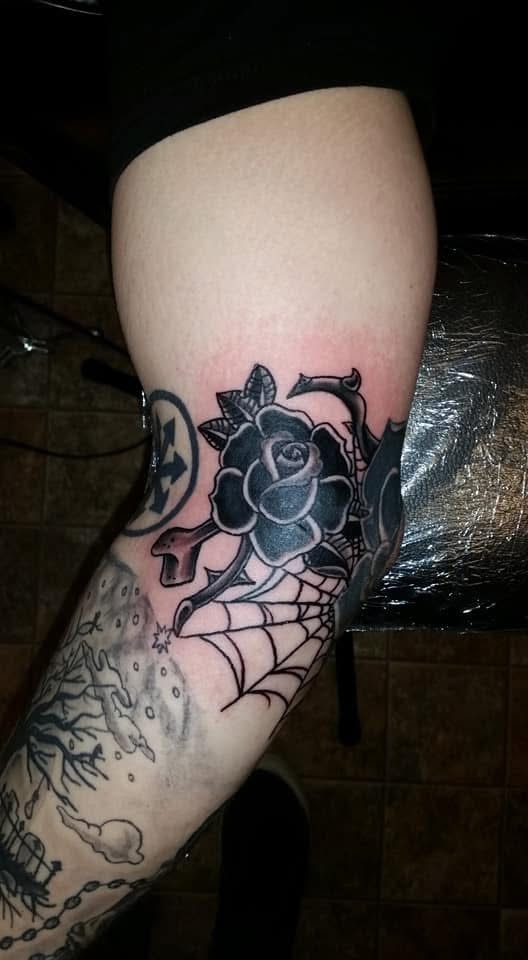 Black rose with spider web knee tattoo
