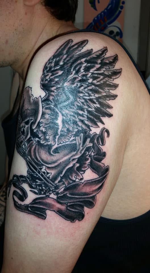 Winged skeleton warrior with banner shoulder tattoo front view