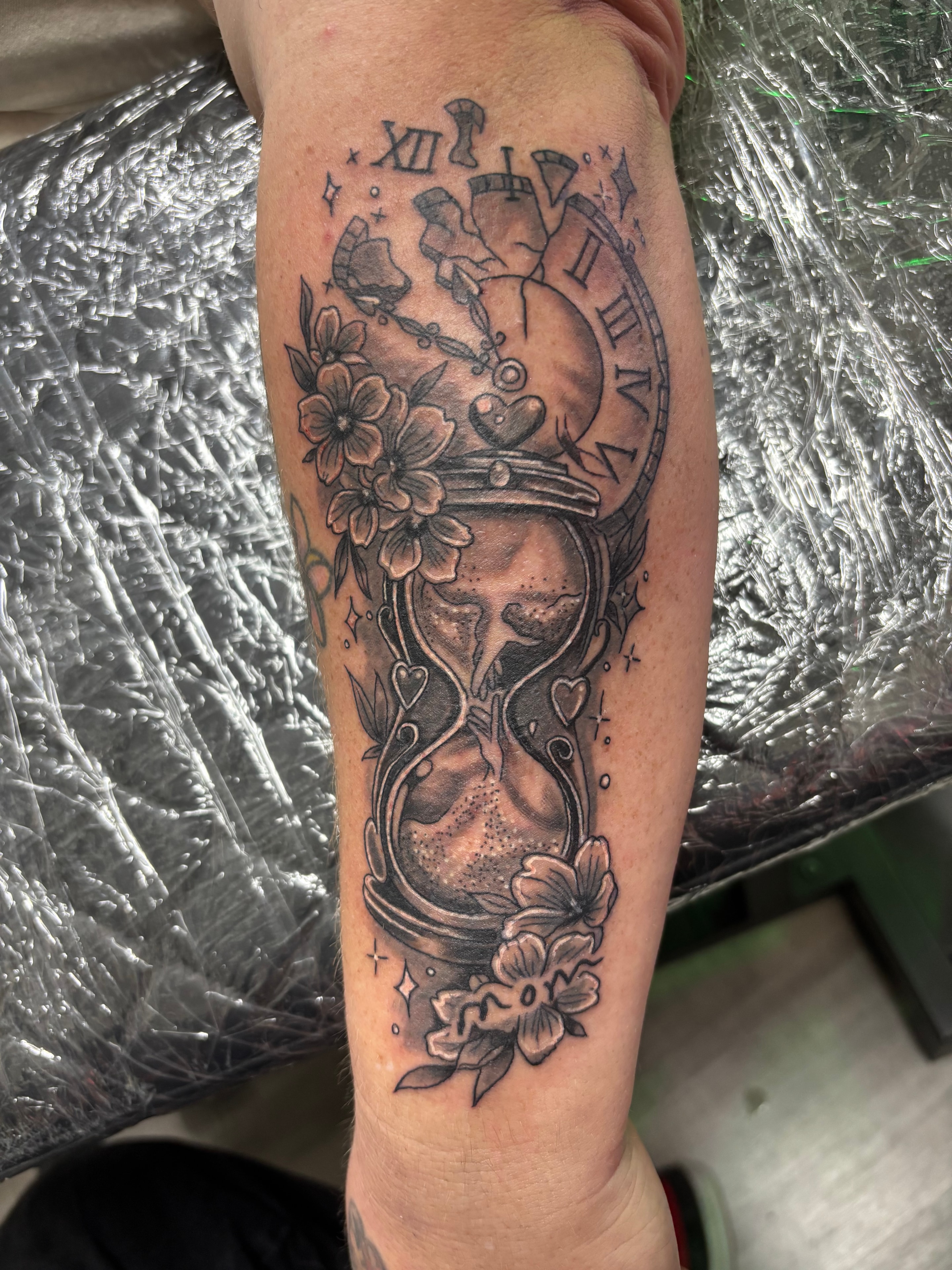 Randy DeShong hourglass clock and flowers forearm tattoo